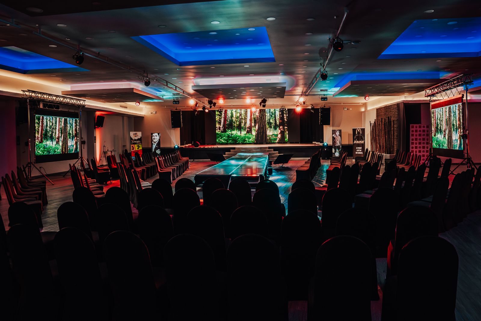 Gran sala de convenciones corporativas con escenario y asistentes